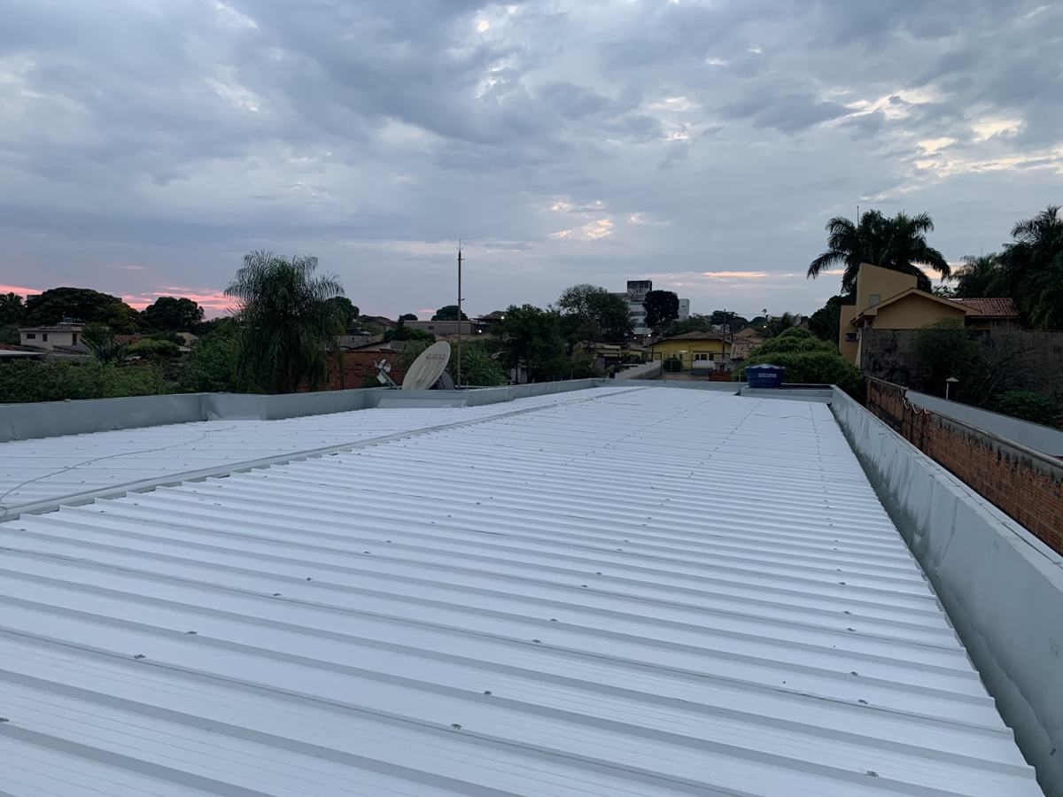 Cobertura metálica nova instalada sobre edificação comercial